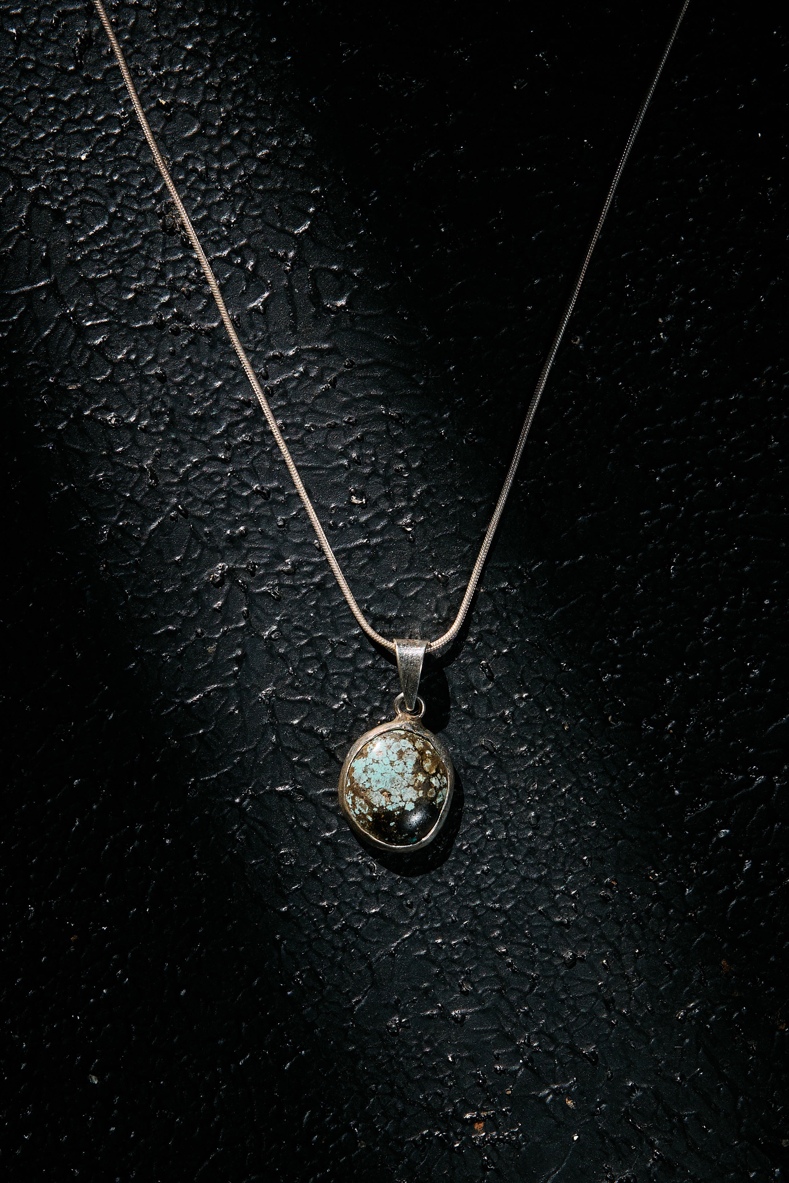 Necklace with a pendant on a dark textured surface