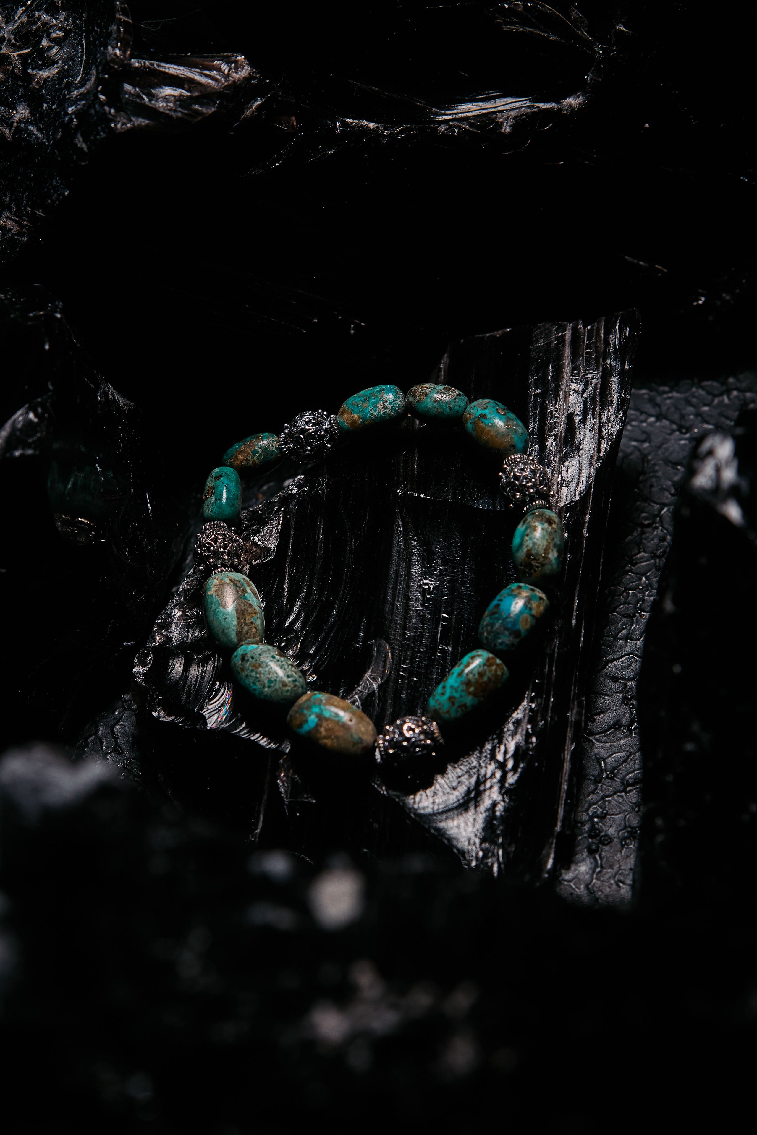 Turquoise beaded bracelet on a dark, textured surface