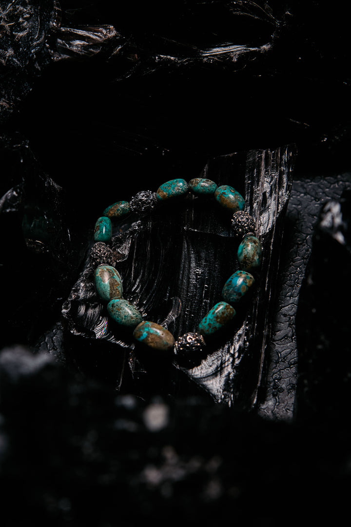 Turquoise beaded bracelet on a dark, textured surface