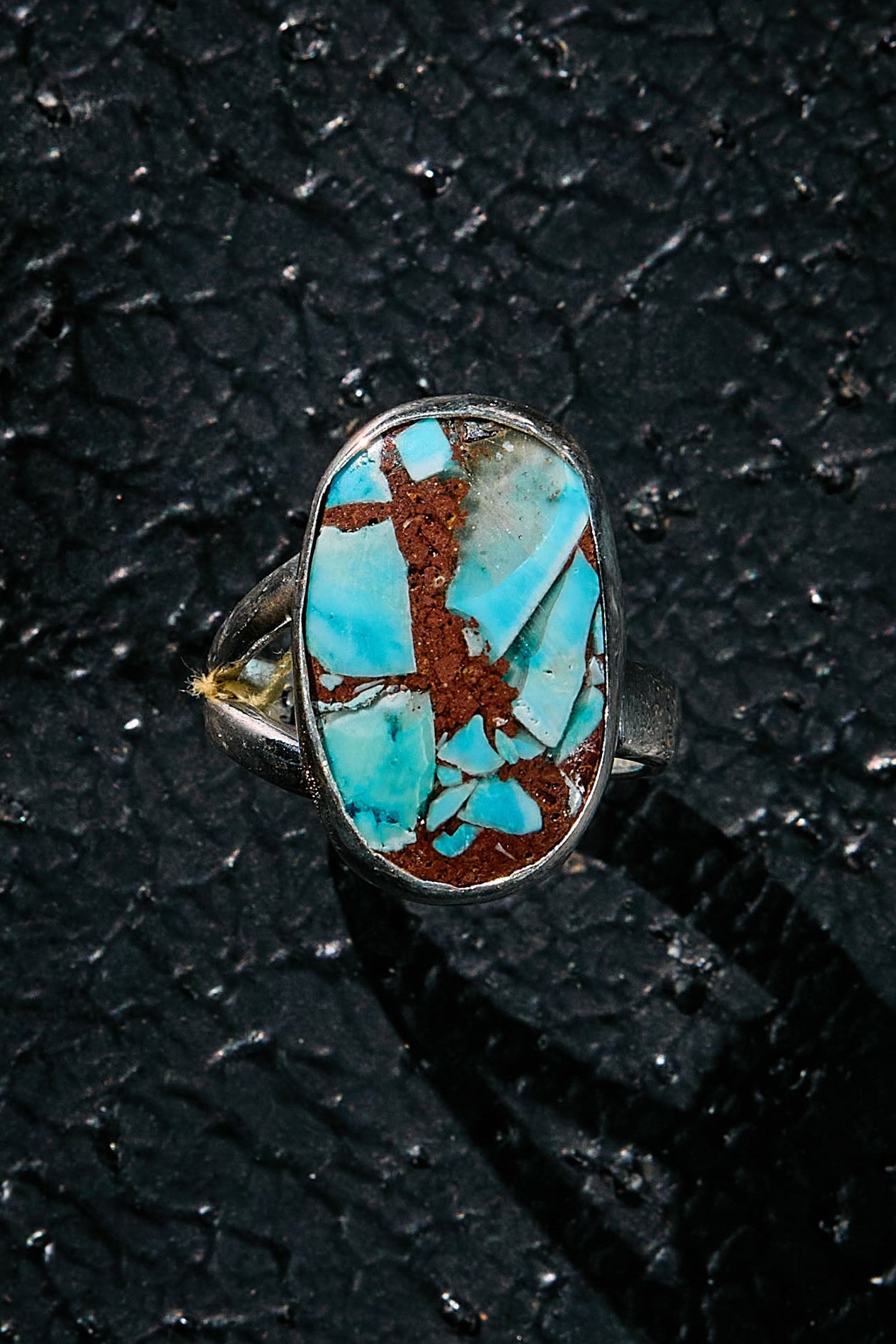 Turquoise ring on a textured black surface