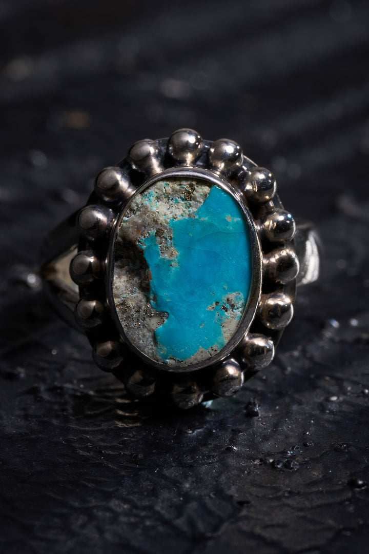 Turquoise ring with silver band with a wise sage carved inside of this.