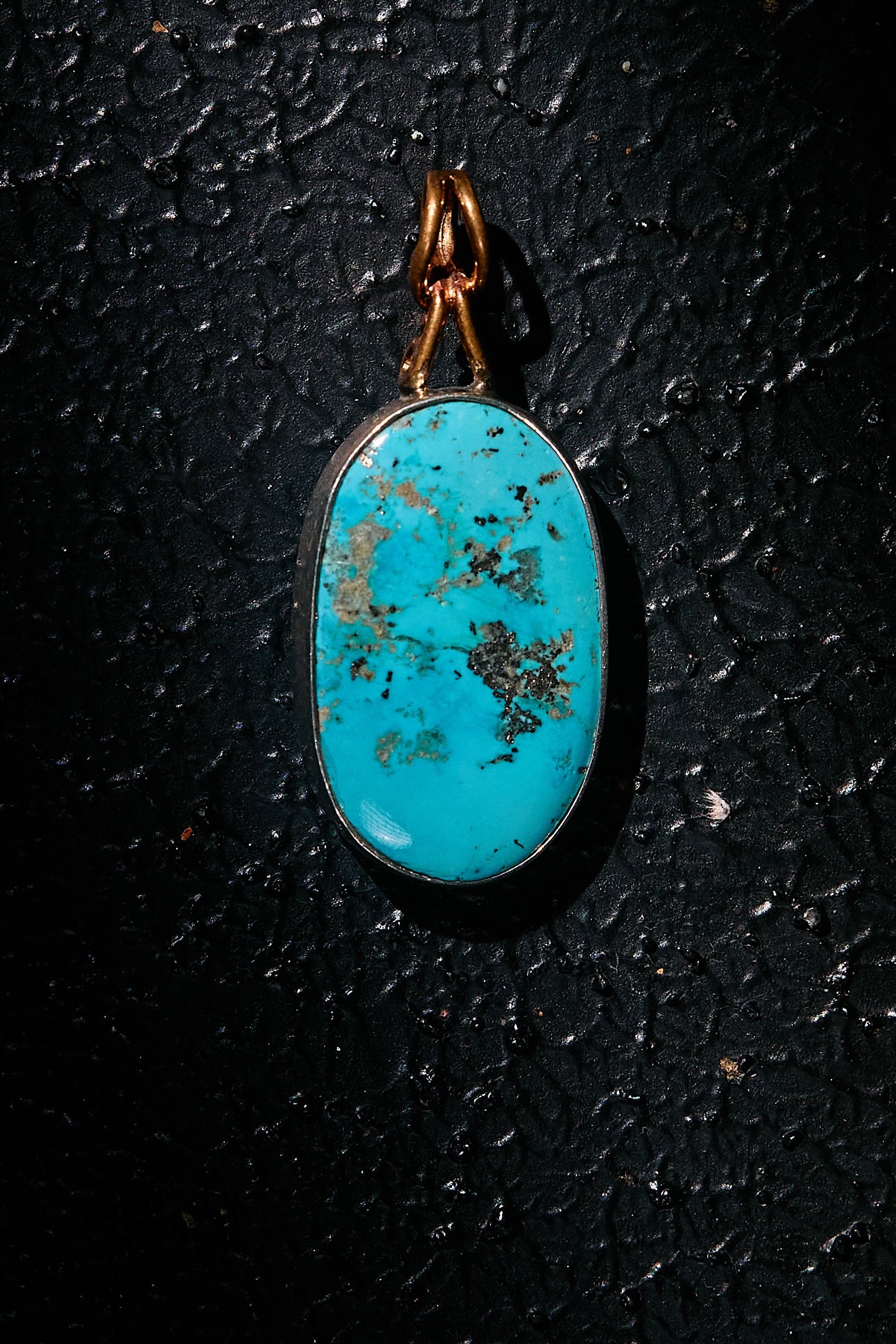 Turquoise pendant on 925 silver a dark textured background
