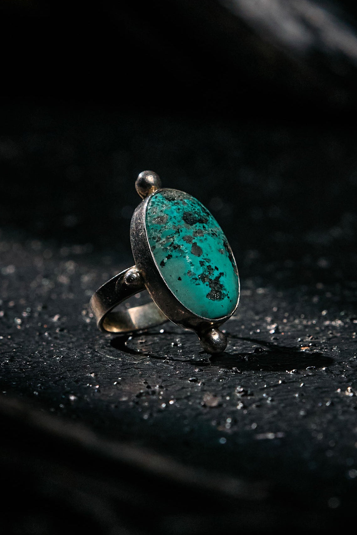 Silver ring with a turquoise stone on a dark surface