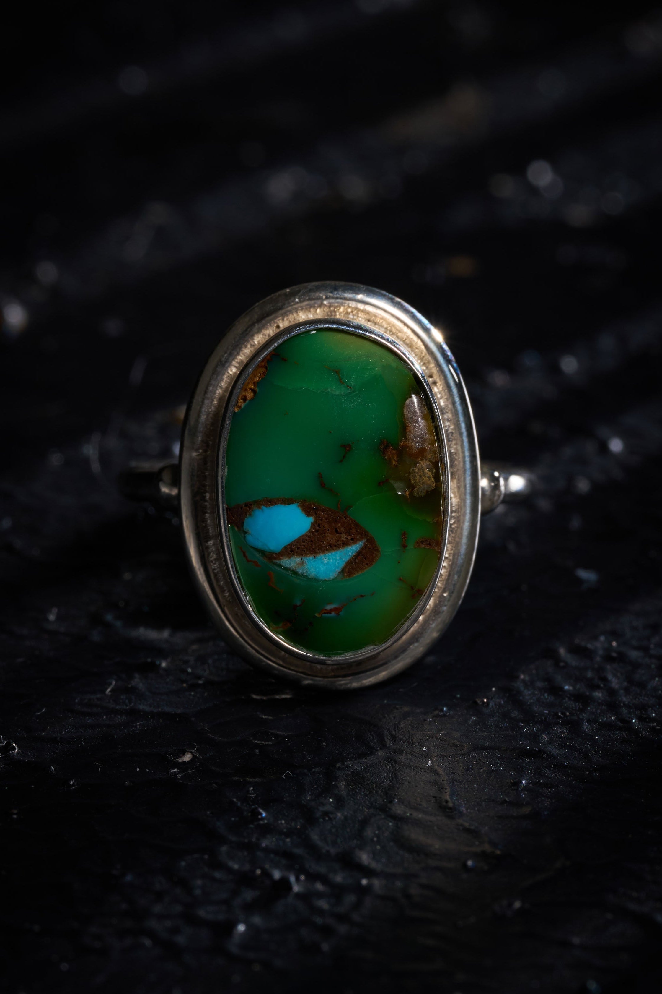 Silver ring with a rare green turquoise stone with a mantaray in the middle. 